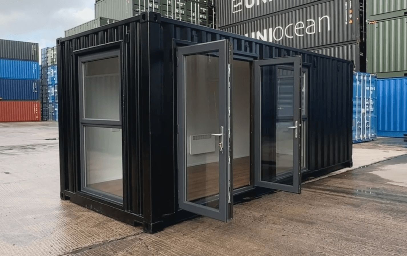 Black container office unit with windows and glass doors